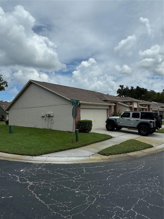 view of property exterior with a garage and a lawn