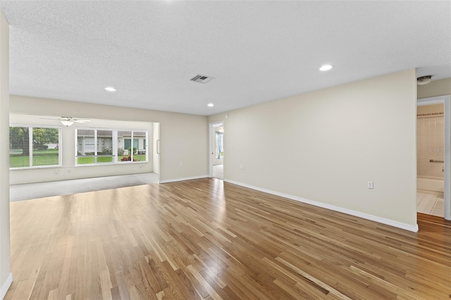 unfurnished living room featuring light hardwood / wood-style floors, a textured ceiling, and ceiling fan