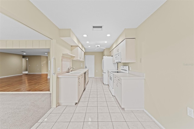 kitchen with light carpet, white cabinets, sink, and white appliances