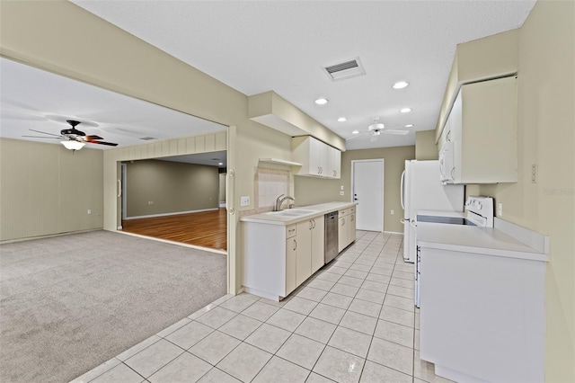 kitchen with light carpet, white cabinets, ceiling fan, sink, and white appliances