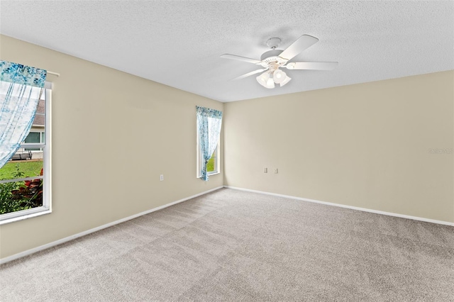 unfurnished room featuring ceiling fan, a textured ceiling, and light colored carpet