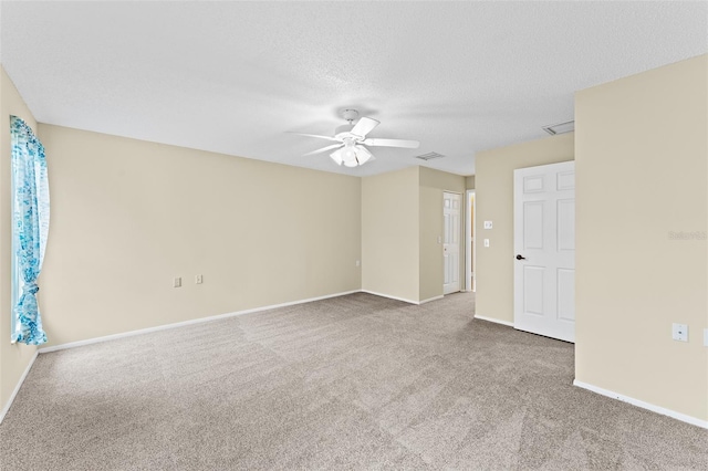 spare room featuring a textured ceiling, carpet, and ceiling fan