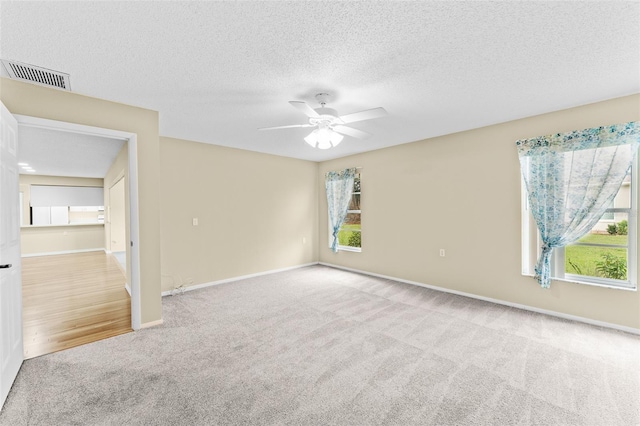 carpeted empty room featuring a textured ceiling and ceiling fan