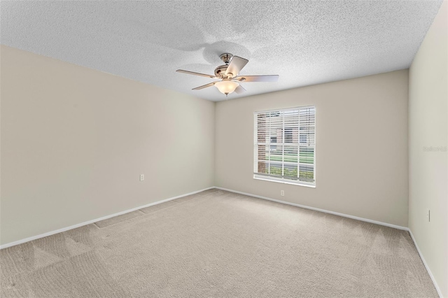 carpeted spare room featuring ceiling fan and a textured ceiling