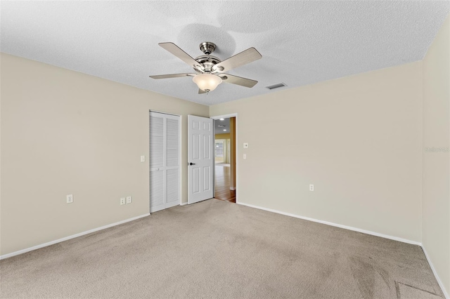 carpeted empty room featuring a textured ceiling and ceiling fan