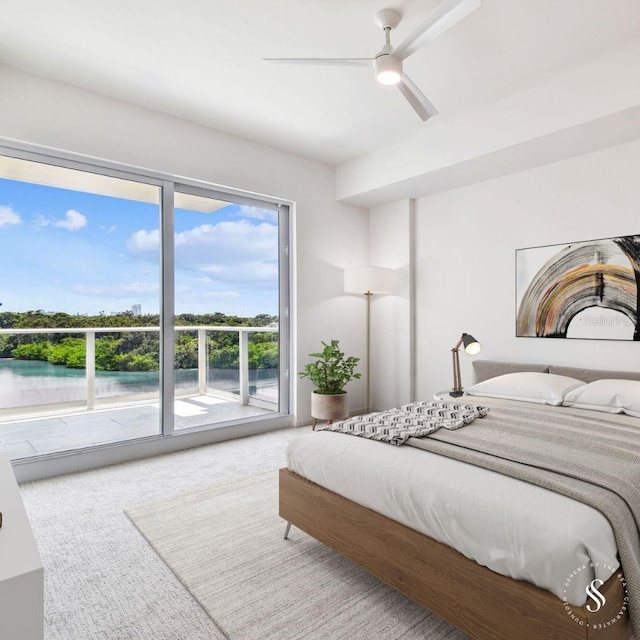 carpeted bedroom with a water view, access to outside, and ceiling fan