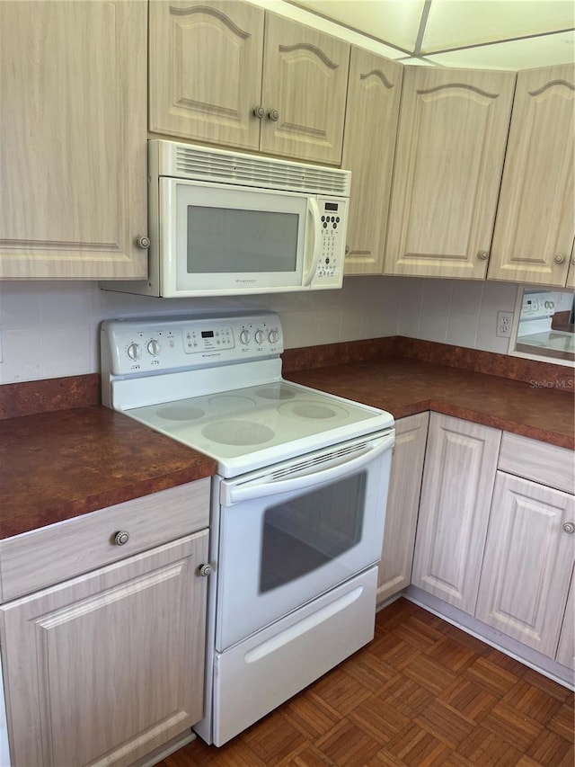 kitchen featuring dark parquet flooring, tasteful backsplash, and white appliances