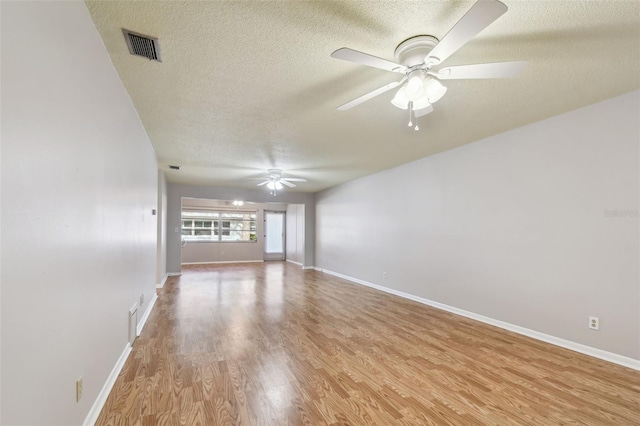 unfurnished living room with ceiling fan, a textured ceiling, and light wood-type flooring