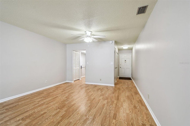 unfurnished room with ceiling fan, light hardwood / wood-style flooring, and a textured ceiling