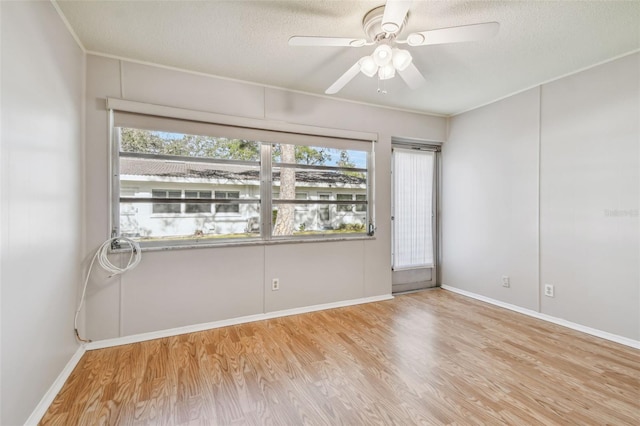 spare room with a textured ceiling, light hardwood / wood-style flooring, ceiling fan, and a healthy amount of sunlight