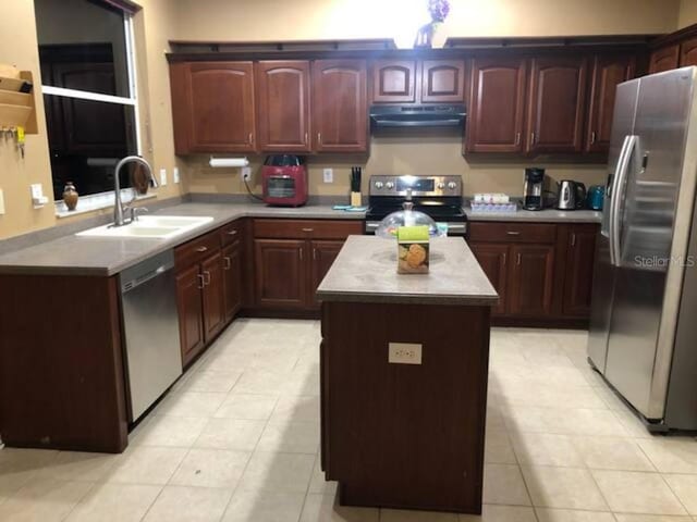 kitchen with light tile patterned flooring, appliances with stainless steel finishes, sink, and kitchen peninsula