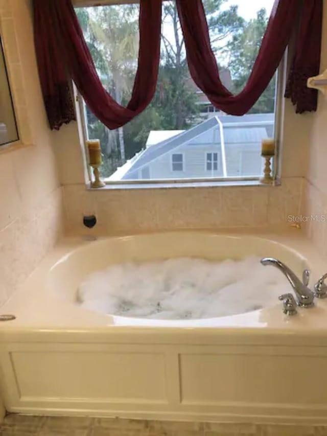 bathroom featuring plenty of natural light and a washtub