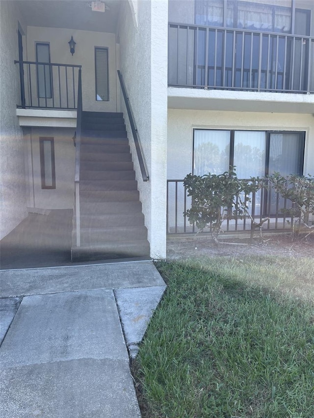 2688 Pine Ridge Way N Unit D1, Palm Harbor, FL 34684 - doorway to property featuring stucco siding and a balcony