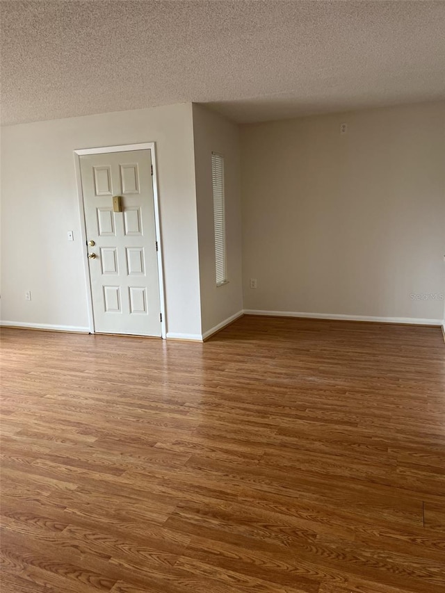 2688 Pine Ridge Way N Unit D1, Palm Harbor, FL 34684 - unfurnished room with dark wood-type flooring, a textured ceiling, and baseboards