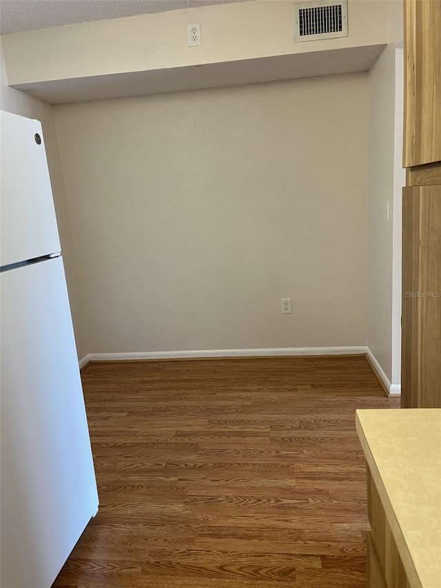 kitchen with dark hardwood / wood-style floors, a textured ceiling, and white refrigerator