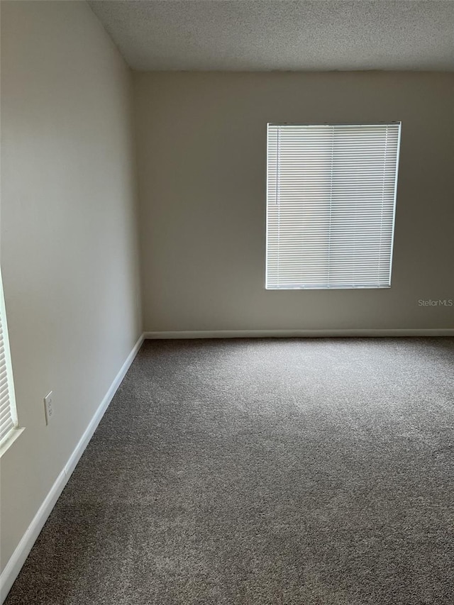2688 Pine Ridge Way N Unit D1, Palm Harbor, FL 34684 - carpeted spare room featuring baseboards and a textured ceiling