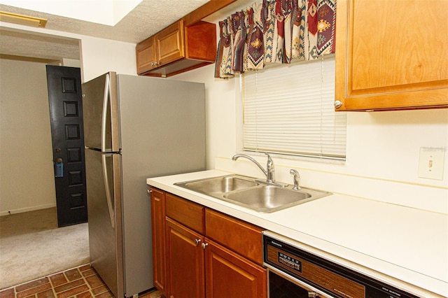 kitchen featuring stainless steel refrigerator, sink, a textured ceiling, and black dishwasher