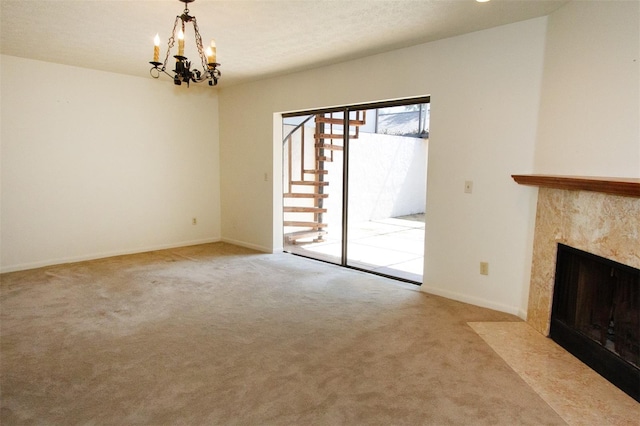 unfurnished living room with light colored carpet, an inviting chandelier, a premium fireplace, and a textured ceiling