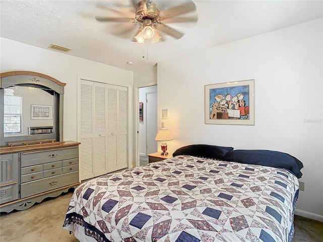 carpeted bedroom featuring ceiling fan and a closet