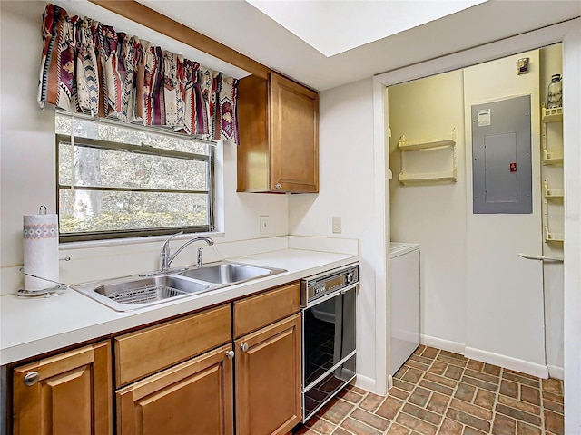 kitchen with electric panel, sink, and washing machine and dryer