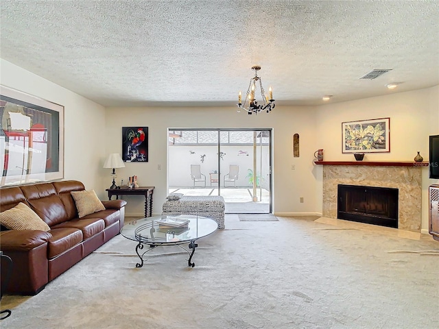 carpeted living room featuring a fireplace, a chandelier, and a textured ceiling