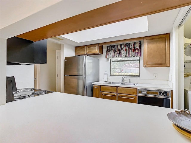 kitchen with stainless steel fridge, stove, range hood, sink, and dishwasher