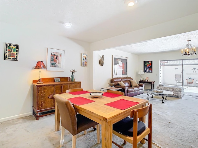 dining room featuring a chandelier, a textured ceiling, and light carpet