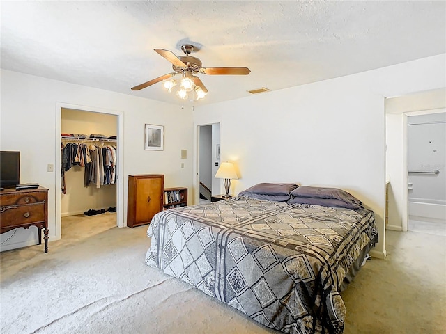 bedroom featuring ceiling fan, a closet, carpet, and a spacious closet