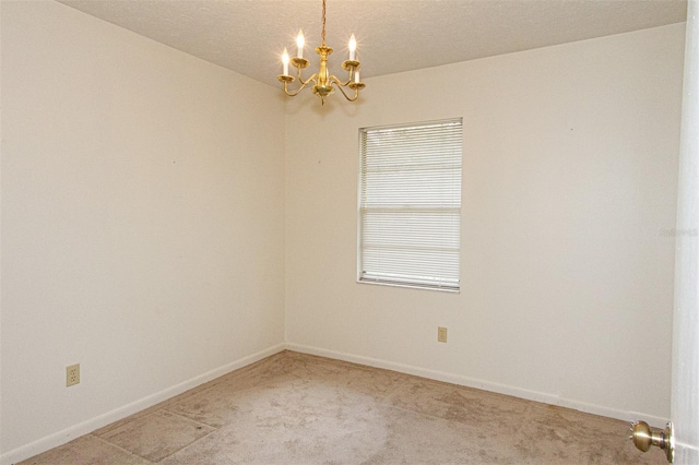 carpeted spare room with an inviting chandelier and a textured ceiling