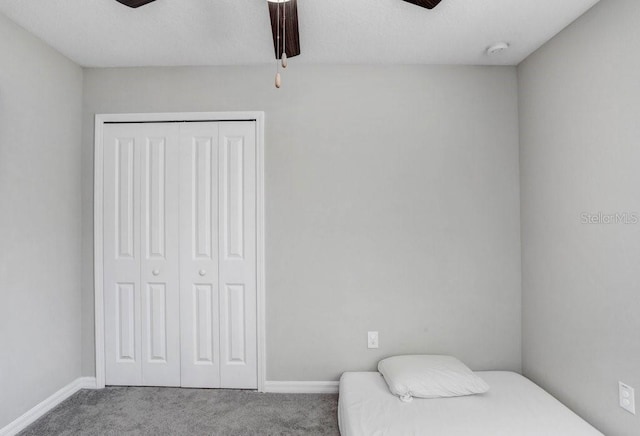 carpeted bedroom featuring a closet and ceiling fan