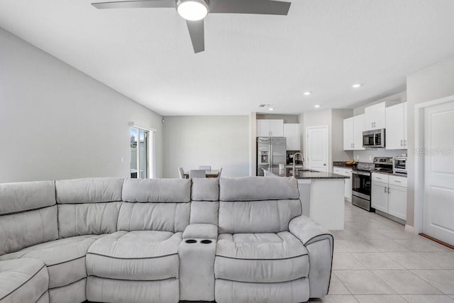 tiled living room featuring ceiling fan and sink