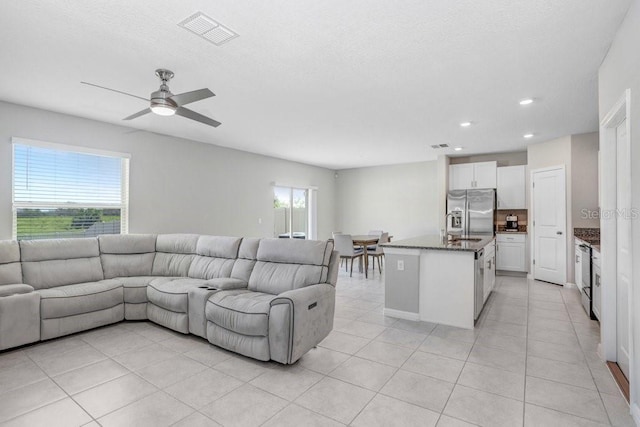 living room with light tile patterned flooring, ceiling fan, and plenty of natural light