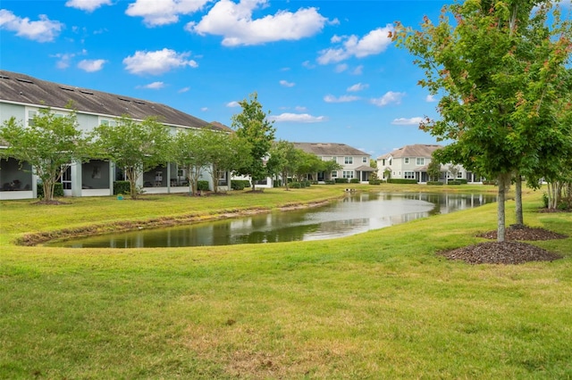 view of property's community with a water view and a lawn