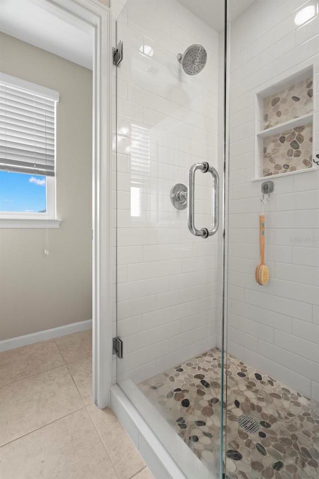 bathroom featuring a shower with shower door and tile patterned floors