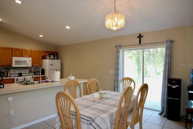 tiled dining area featuring lofted ceiling, sink, and a chandelier