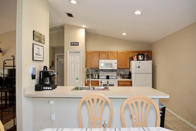 kitchen with light tile patterned flooring, sink, tasteful backsplash, white appliances, and vaulted ceiling