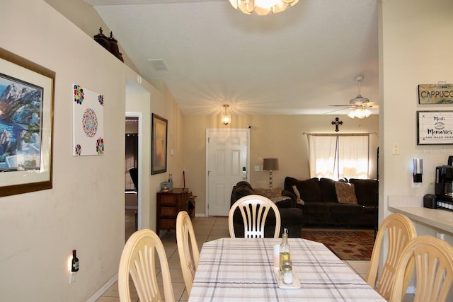 tiled dining area featuring vaulted ceiling and ceiling fan