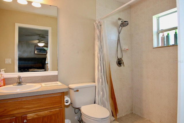 bathroom with ceiling fan, a shower with shower curtain, vanity, and toilet