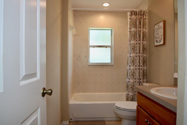 full bathroom with shower / bathtub combination with curtain, tile patterned floors, vanity, and toilet