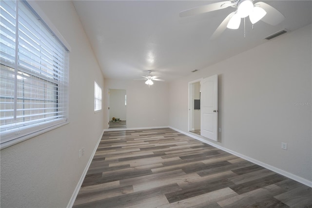 unfurnished room with ceiling fan and dark wood-type flooring