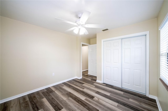 unfurnished bedroom with ceiling fan, a closet, and dark hardwood / wood-style floors