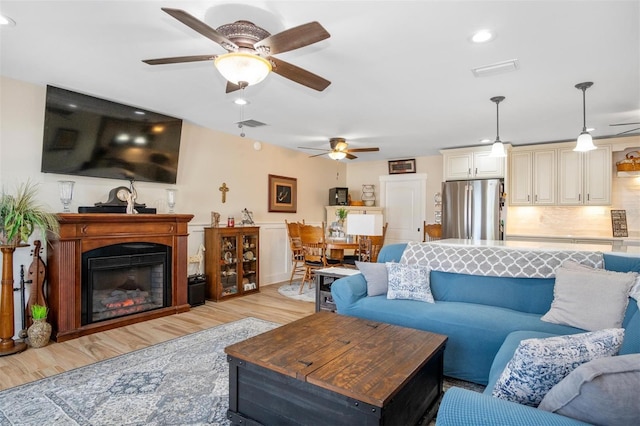 living room with ceiling fan and light wood-type flooring