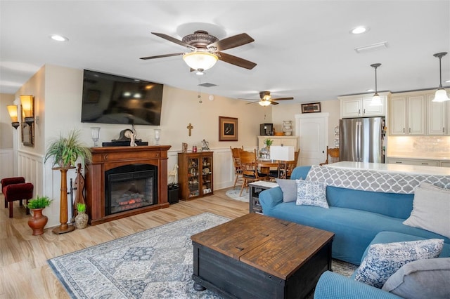 living room featuring ceiling fan and light wood-type flooring