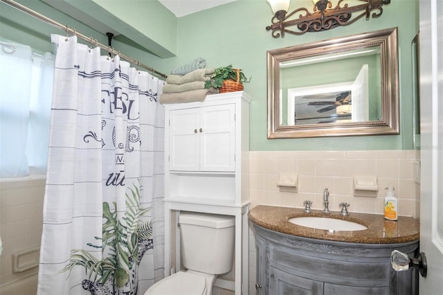 bathroom featuring vanity, tile walls, and toilet