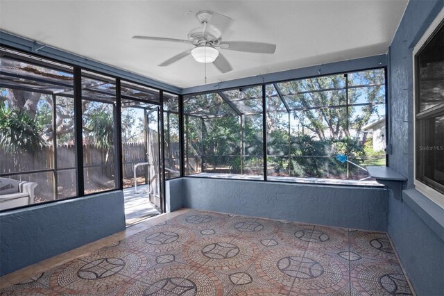 unfurnished sunroom featuring ceiling fan