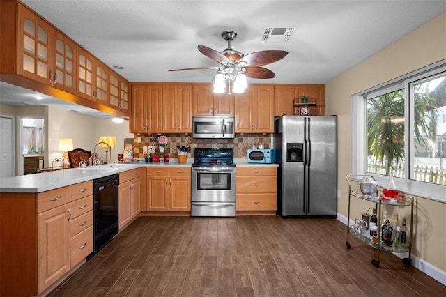 kitchen with visible vents, appliances with stainless steel finishes, a peninsula, light countertops, and a sink