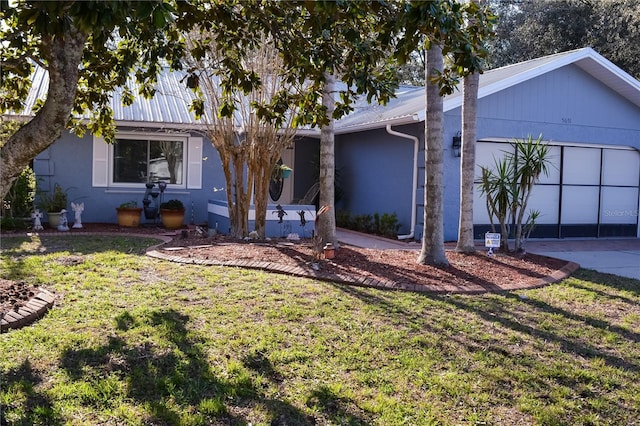 view of front of house with a garage, a front yard, driveway, and stucco siding