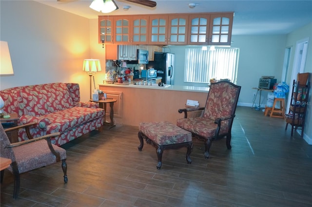 living area with ceiling fan, baseboards, and wood finished floors