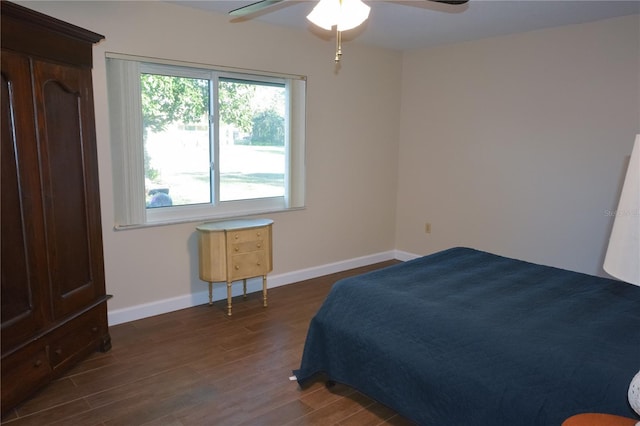 bedroom featuring dark wood-style flooring, ceiling fan, and baseboards