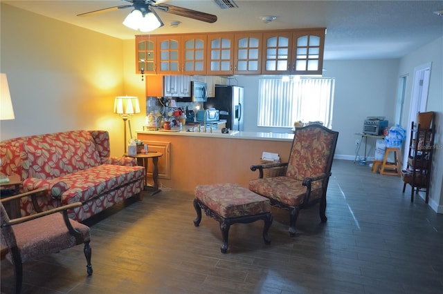 sitting room featuring a ceiling fan, visible vents, baseboards, and wood finished floors